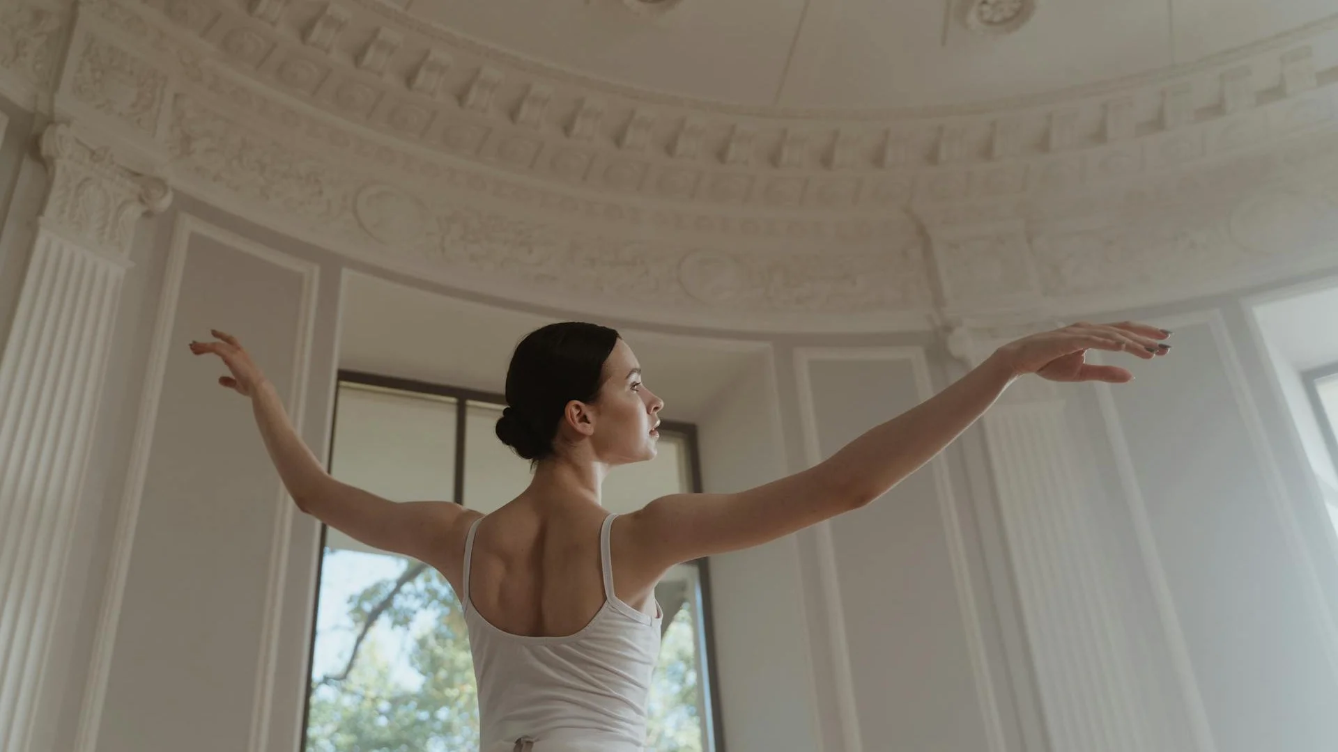 A solo dancer in a dust-lit, war-torn setting, illustrative of Xenos